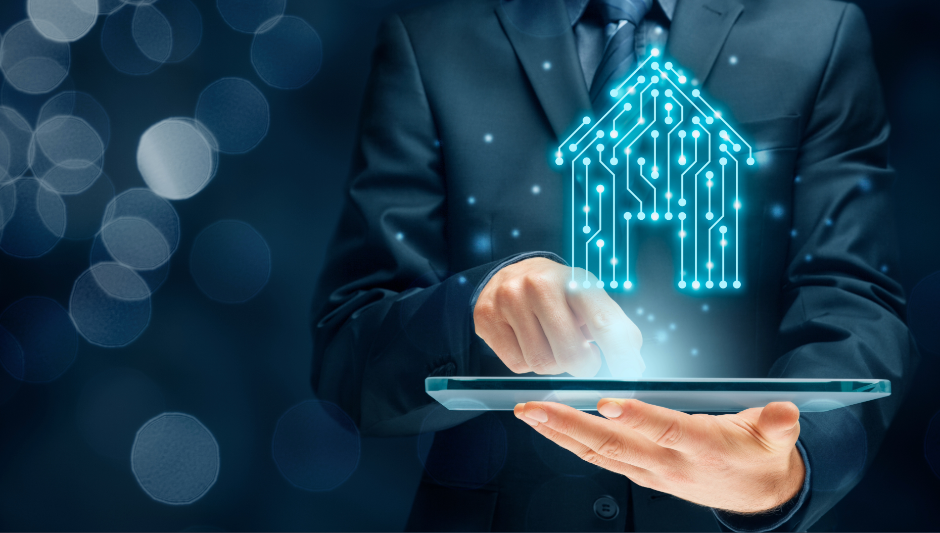 Man in suit holding a tablet with a glowing house icon on a dark background